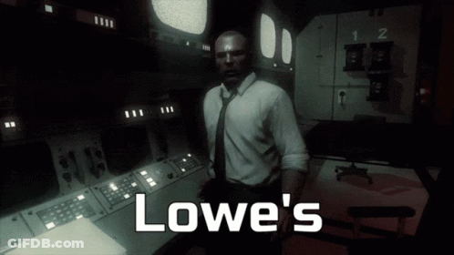 A Man In A Suit And Tie Stands In A Dark Room With The Words Lowe 'S Written On The Bottom GIF