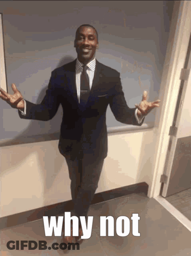 A Man In A Suit And Tie Stands In A Hallway With His Arms Outstretched And The Words Why Not Below Him GIF