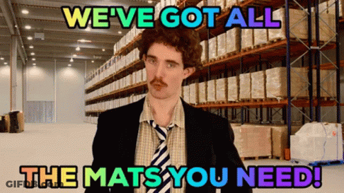 A Man In A Suit And Tie Stands In A Warehouse With The Words " We 'Ve Got All The Mats You Need " Above Him GIF