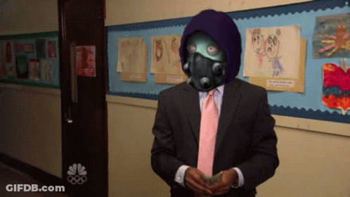 A Man In A Suit And Tie Stands In Front Of A Bulletin Board GIF