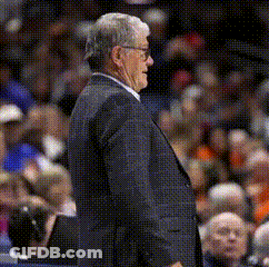 A Man In A Suit And Tie Stands In Front Of A Crowd GIF