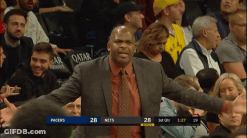 A Man In A Suit And Tie Stands In Front Of A Crowd Watching A Basketball Game Between Pacers And Nets GIF