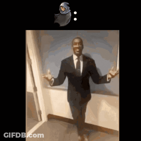 A Man In A Suit And Tie Stands In Front Of A Door GIF