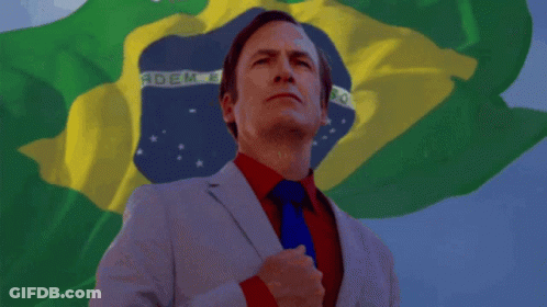 A Man In A Suit And Tie Stands In Front Of A Flag That Says Brasil GIF