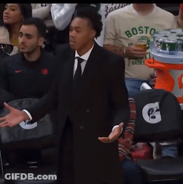 A Man In A Suit And Tie Stands In Front Of A Gatorade Stand GIF