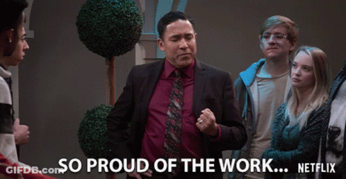 A Man In A Suit And Tie Stands In Front Of A Group Of People And Says So Proud Of The Work Netflix GIF