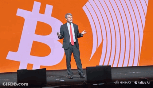 Man In Suit Standing In Front Of Large B GIF