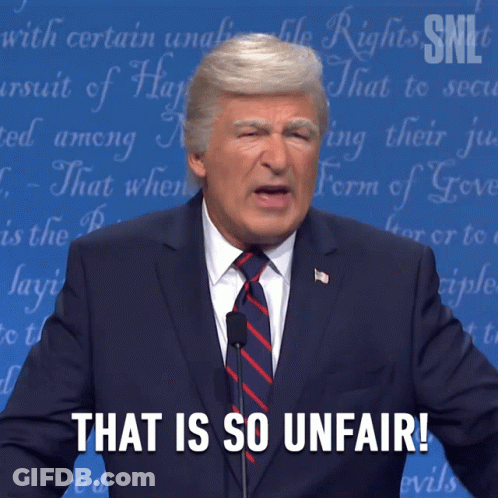 A Man In A Suit And Tie Stands In Front Of A Microphone And Says That Is So Unfair GIF