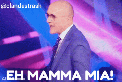 A Man In A Suit And Tie Stands In Front Of A Purple Background And Says " Eh Mamma Mia " GIF