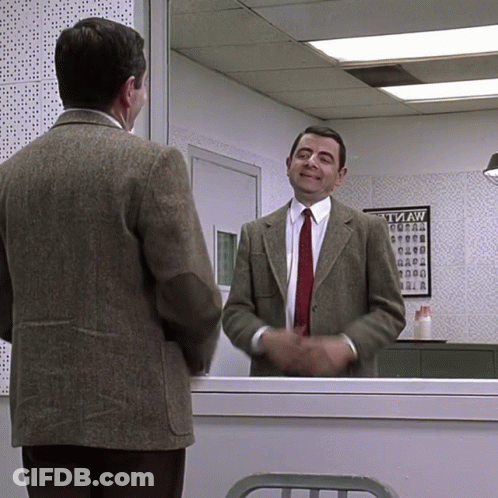 A Man In A Suit And Tie Stands In Front Of A Tvaw Poster GIF