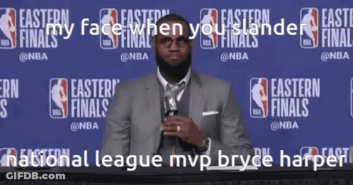 A Man In A Suit And Tie Stands In Front Of A Wall That Says Easter Finals GIF