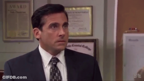 A Man In A Suit And Tie Stands In Front Of A Wall With A Certificate That Says Award On It GIF