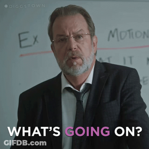 A Man In A Suit And Tie Stands In Front Of A White Board That Says Ex Motion And What 'S Going On GIF