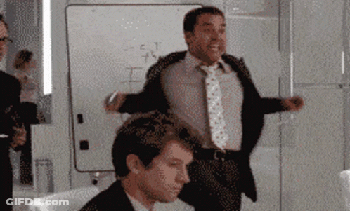 A Man In A Suit And Tie Stands In Front Of A White Board That Says " S = C = T " On It GIF