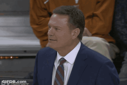 A Man In A Suit And Tie Stands In Front Of Dvsport GIF