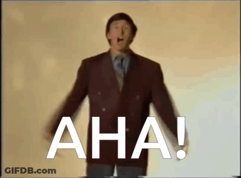 A Man In A Suit And Tie Stands In Front Of The Word Aha GIF