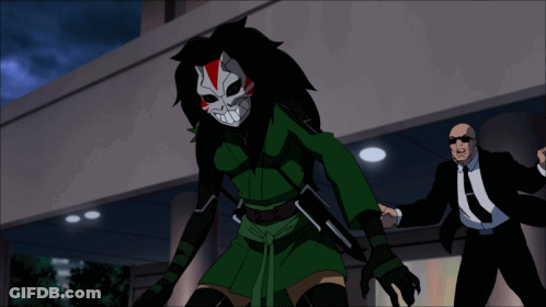 A Man In A Suit And Tie Stands Next To A Cartoon Character In A Mask GIF