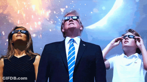 A Man In A Suit And Tie Stands Next To A Woman And A Child Wearing Sunglasses GIF
