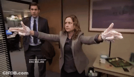 A Man In A Suit And Tie Stands Next To A Woman Wearing Gloves GIF