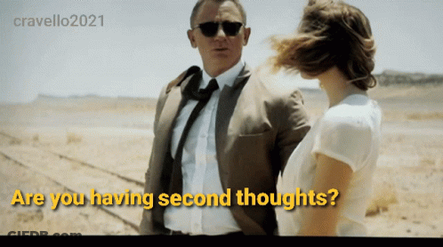 A Man In A Suit And Tie Stands Next To A Woman With The Words " Are You Having Second Thoughts " Above Them GIF