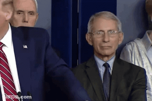 A Man In A Suit And Tie Stands Next To Another Man In A Suit GIF