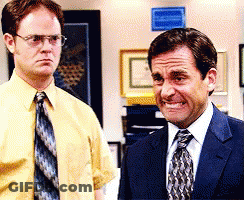 A Man In A Suit And Tie Stands Next To Another Man In A Yellow Shirt And Tie GIF