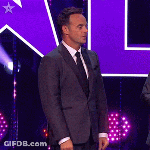 Man In Suit On Stage With Purple Star GIF