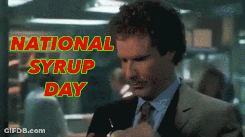 A Man In A Suit And Tie Takes A Sip Of Syrup In Front Of A Sign That Says National Syrup Day GIF