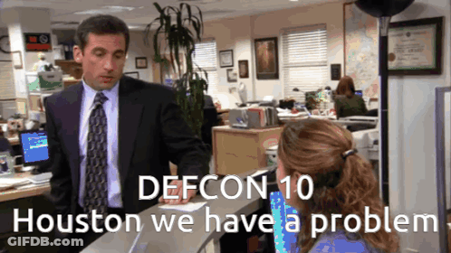 A Man In A Suit And Tie Talking To A Woman In An Office With The Words Defcon 10 GIF