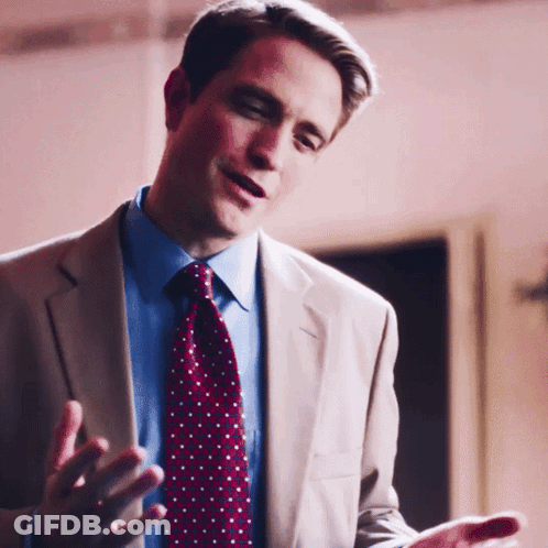 A Man In A Suit And Tie Talking With His Hands Outstretched GIF