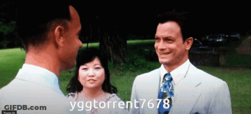 A Man In A Suit And Tie Talks To A Woman And Another Man In A White Suit GIF