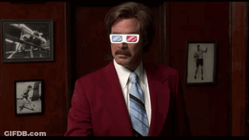 A Man In A Suit And Tie Wearing 3D Glasses GIF