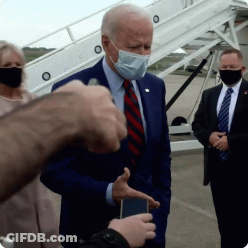 Man In Suit And Mask Talking To Reporter GIF