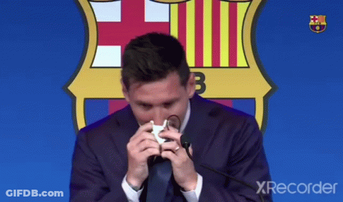 A Man In A Suit And Tie Wipes His Nose With A Napkin In Front Of A Fcb Logo GIF
