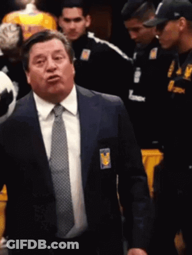 A Man In A Suit And Tie With A Badge That Says Tigres GIF