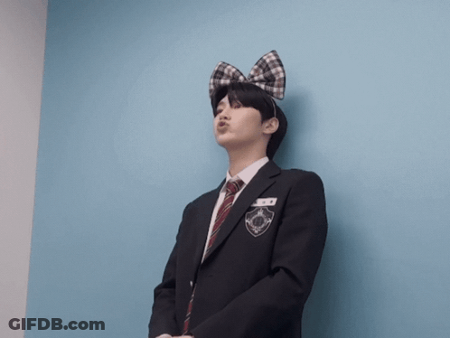 A Man In A Suit And Tie With A Bow On His Head Is Making A Face GIF