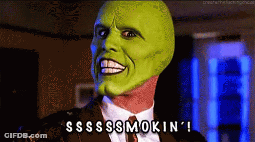 A Man In A Suit And Tie With A Green Mask On His Face Says Sss Smokin ' GIF