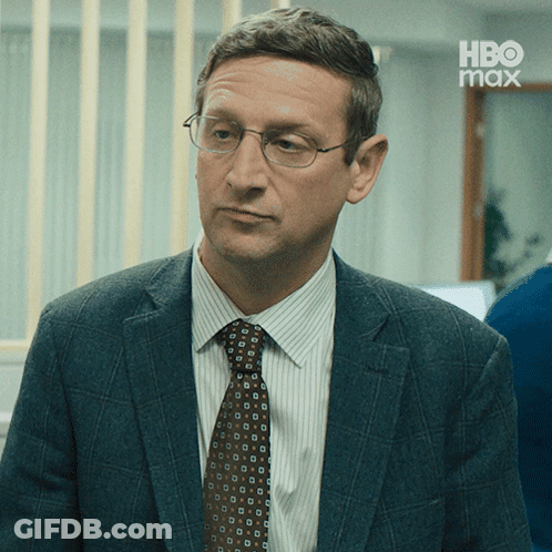 A Man In A Suit And Tie With A Hbo Max Logo In The Background GIF