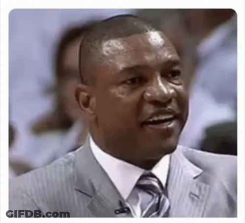 A Man In A Suit And Tie With A Microphone In His Ear Is Smiling . GIF