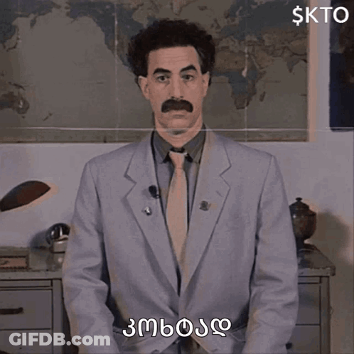 A Man In A Suit And Tie With A Mustache Is Standing In Front Of A Map Of The World And Says Kto GIF