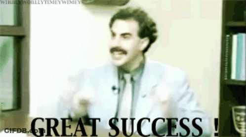 A Man In A Suit And Tie With A Mustache Says Great Success GIF