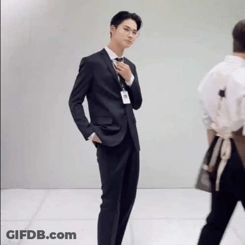 A Man In A Suit And Tie With A Name Tag That Says ' A. ' On It GIF