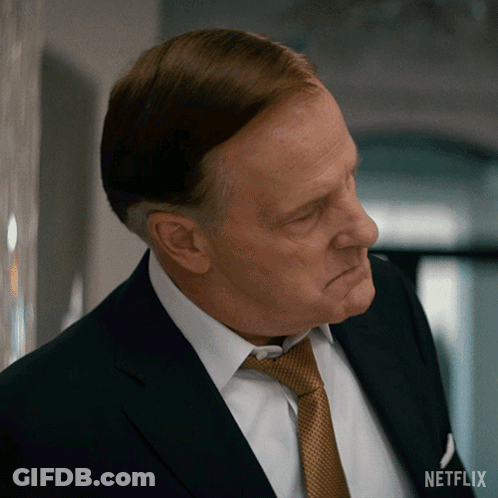 A Man In A Suit And Tie With A Netflix Logo On The Bottom Right GIF