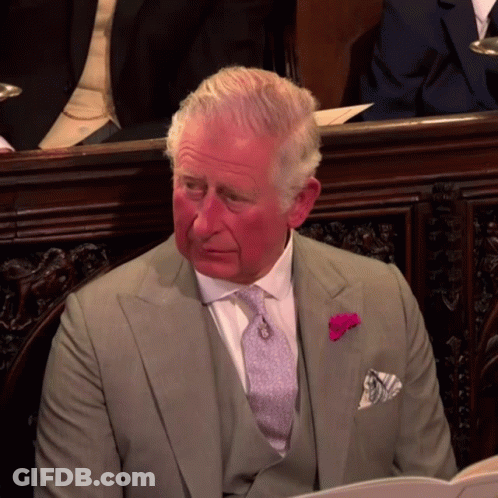 A Man In A Suit And Tie With A Pink Flower Pin On His Pocket Square GIF