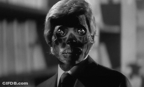 A Man In A Suit And Tie With A Skeleton Mask On His Face . GIF