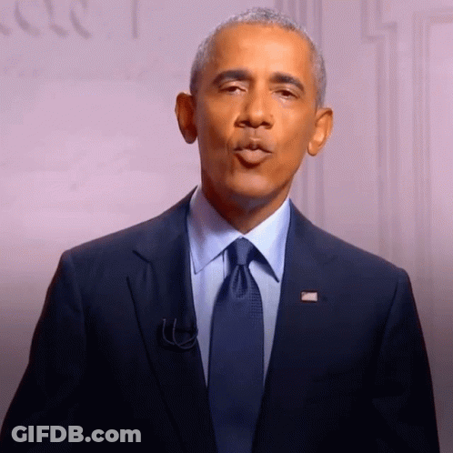 A Man In A Suit And Tie With An American Flag Pin On His Jacket GIF
