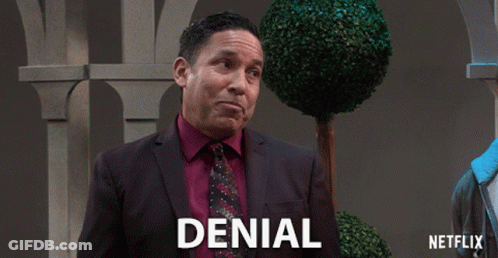 A Man In A Suit And Tie With Denial Written On The Bottom GIF
