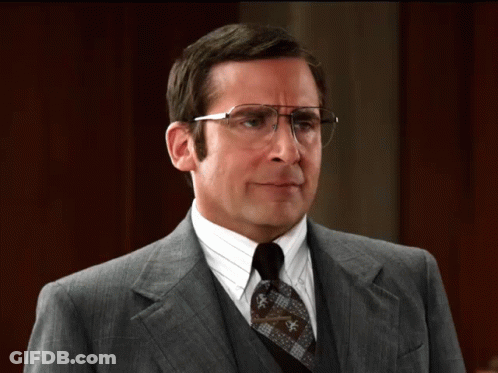 A Man In A Suit And Tie With Glasses GIF