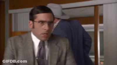 A Man In A Suit And Tie With Glasses And A Clip On His Tie GIF