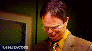 A Man In A Suit And Tie With Glasses Looks Down GIF